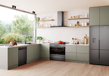 Modern kitchen with Westinghouse black appliances including dishwasher, oven, and fridge, featuring green cabinetry, black faucet, and natural light from garden-facing windows.