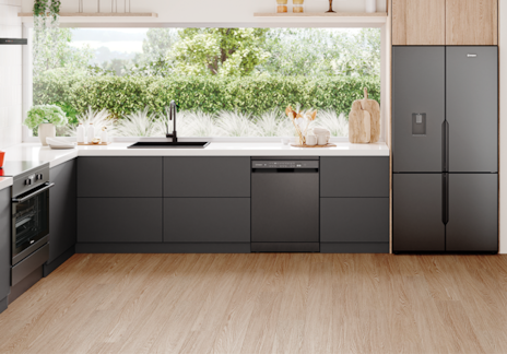 Stylish kitchen with Westinghouse built-in appliances, including oven, dishwasher, and double-door fridge, featuring dark grey cabinets, white countertops, and open shelving with natural light from garden-facing windows.